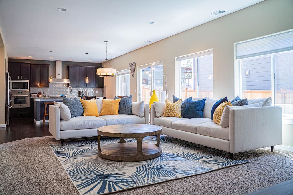 Stretch out and relax in the spacious living room, featuring a long, plush sofa perfect for lounging, complemented by tasteful décor and soft natural light.