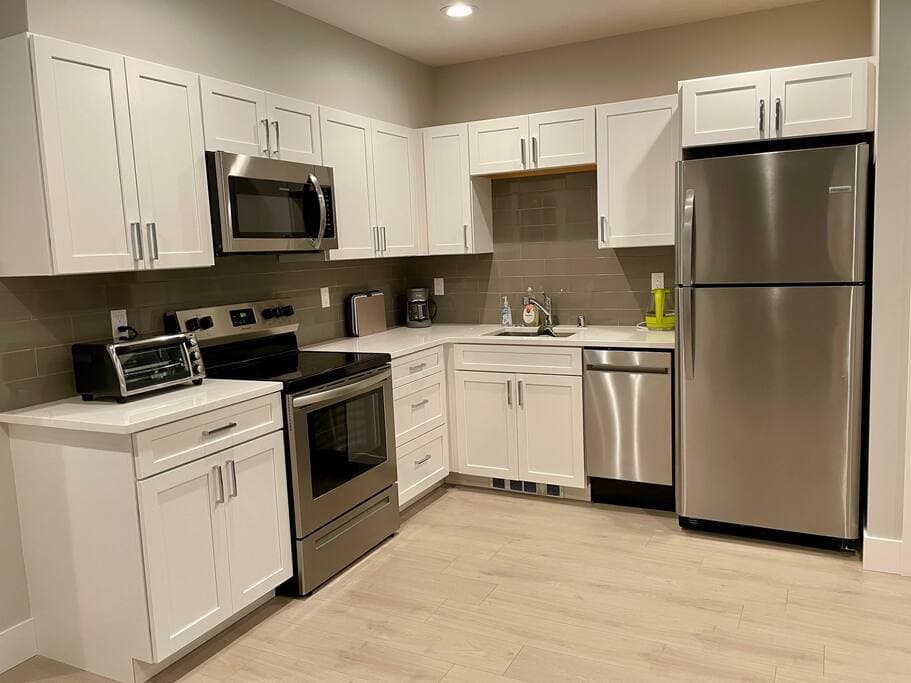 This sleek kitchen features stainless steel appliances, crisp white cabinetry, and plenty of prep space—ideal for cooking up anything from quick bites to full meals.