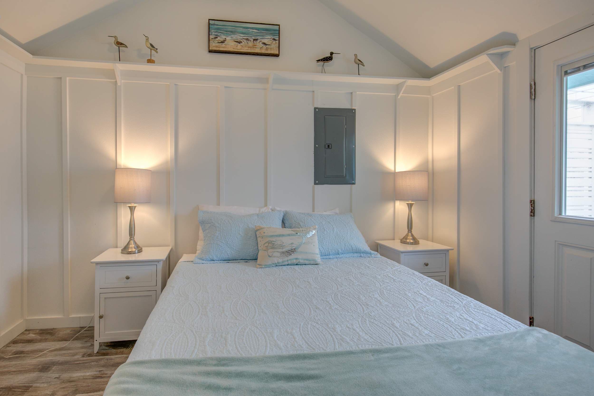 Cozy queen bed set against crisp white walls, creating a clean and calming retreat.