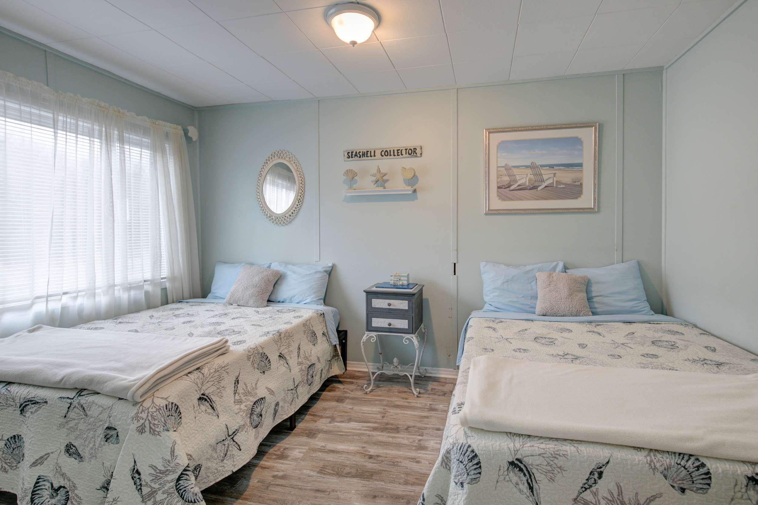A calming retreat with a light blue interior and two double beds.
